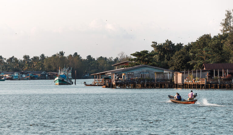 People on a long tail boat on the Ta Pi river